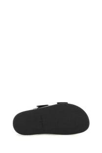 Black rubber sole of tory burch women’s lock sandal featuring minimalist design and subtle branding on the back side