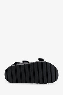 Black rubber sole with vertical ridges on the back of tory burch women’s mellow leather sandals black