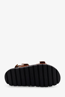 Tory burch women’s mellow low beige leather sandals with black rubber sole featuring vertical grooves