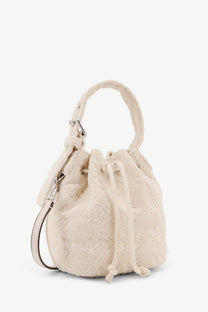 Tory Burch women’s cream-colored monogram terry mini canvas bucket bag with textured fabric handle and drawstring closure