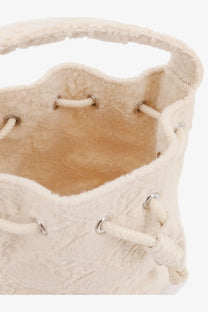 Cream-colored tory burch women’s monogram terry mini canvas bucket bag with textured drawstring closure and metallic eyelets