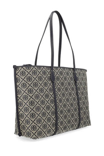 Beige and black Tory Burch women’s monogram tote bag with repeating logo pattern and blue accents