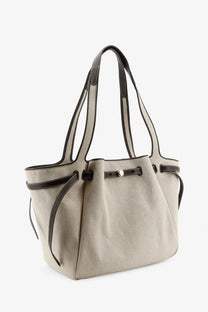 Tory Burch women’s Romy canvas tote bag in beige with black leather trim and handles for stylish everyday use