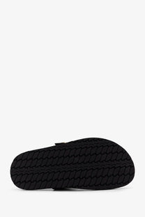 Black rubber sole with textured interlocking tread on the back of tory burch women’s romy leather sandals black