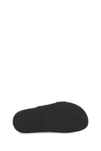 Black rubber sole with minimalist design and subtle branding on Tory Burch women’s sandal lock black