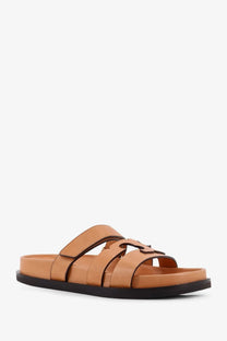 Tory Burch women’s tan leather slide sandal with black rubber sole and t-shaped buckle design in beige