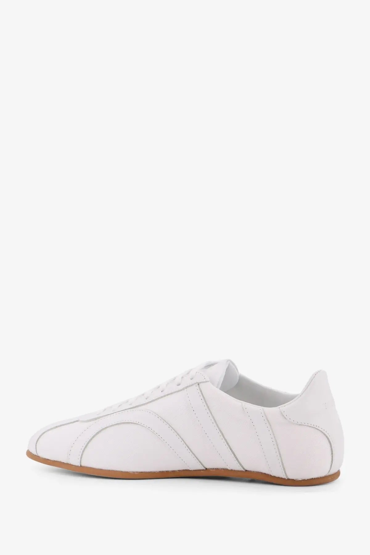 Toteme women’s white leather low top sneaker with subtle stitched paneling and tan rubber sole