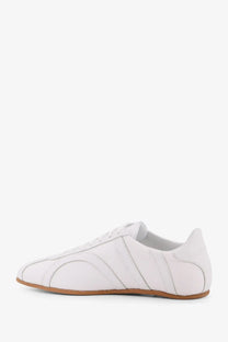 Toteme women’s white leather low top sneaker with subtle stitched paneling and tan rubber sole