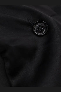 Black glossy four-hole button embossed with text on the toteme women’s cowl neck viscose and linen shirt black