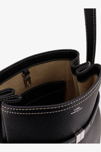 Toteme women’s hammered leather bucket bag in black with black pebbled leather, white stitching, and silver-tone clasp