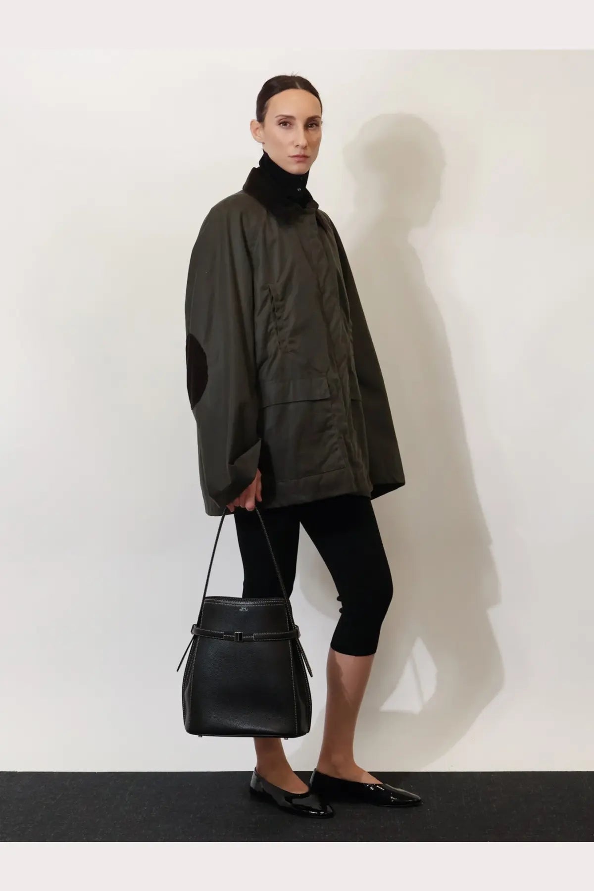 Toteme women’s hammered leather bucket bag in black with a structured shape and front tie closure