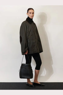 Toteme women’s hammered leather bucket bag in black with a structured shape and front tie closure