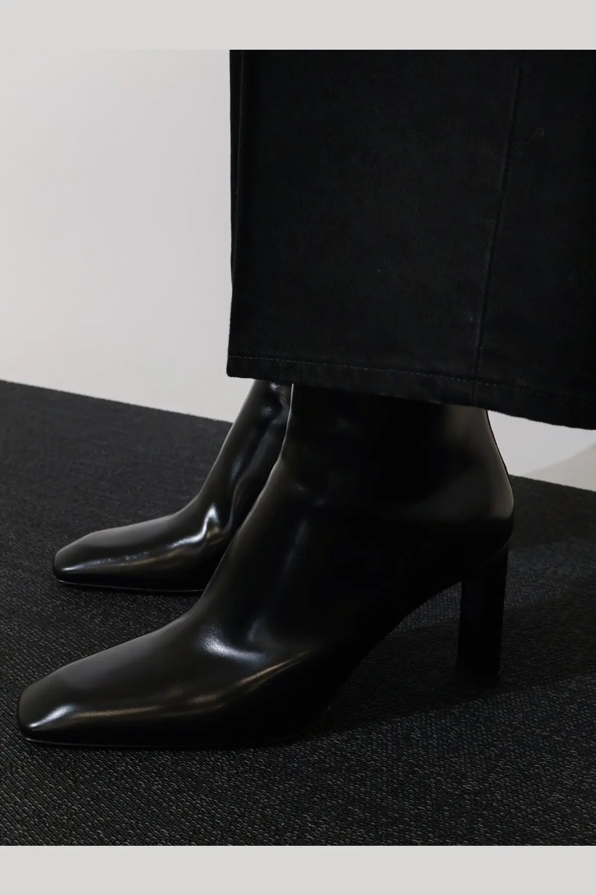 Toteme women’s black leather ankle boots with sleek square-toe design and modest block heel