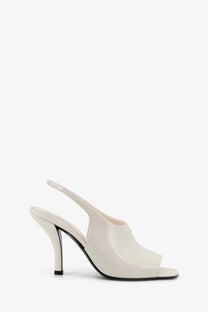 Toteme women’s cream patent leather slingback pump with sleek modern design and black heel in white contour sandals style
