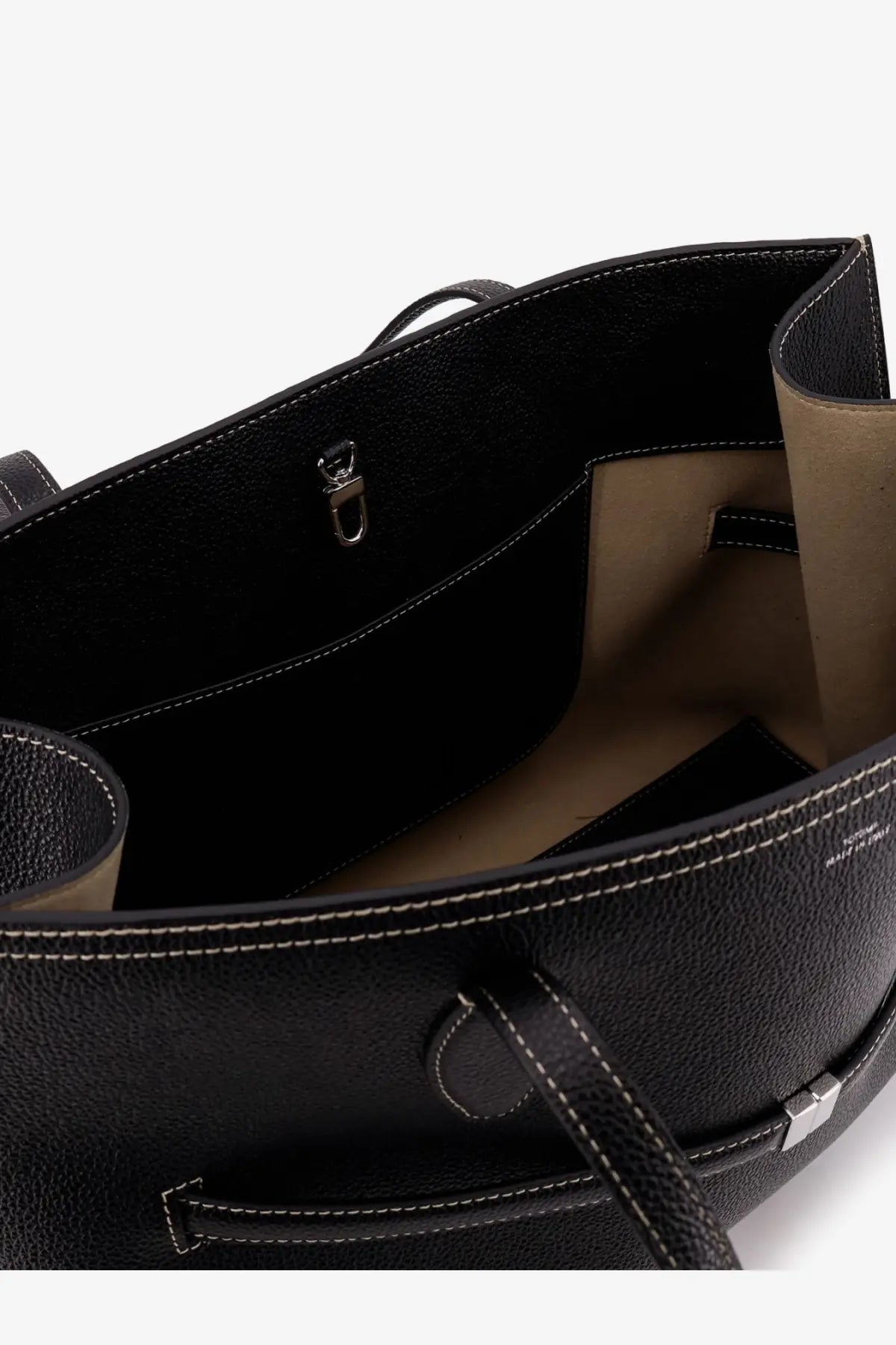 Toteme women’s black leather tote bag with textured leather, white stitching, and beige interior lining