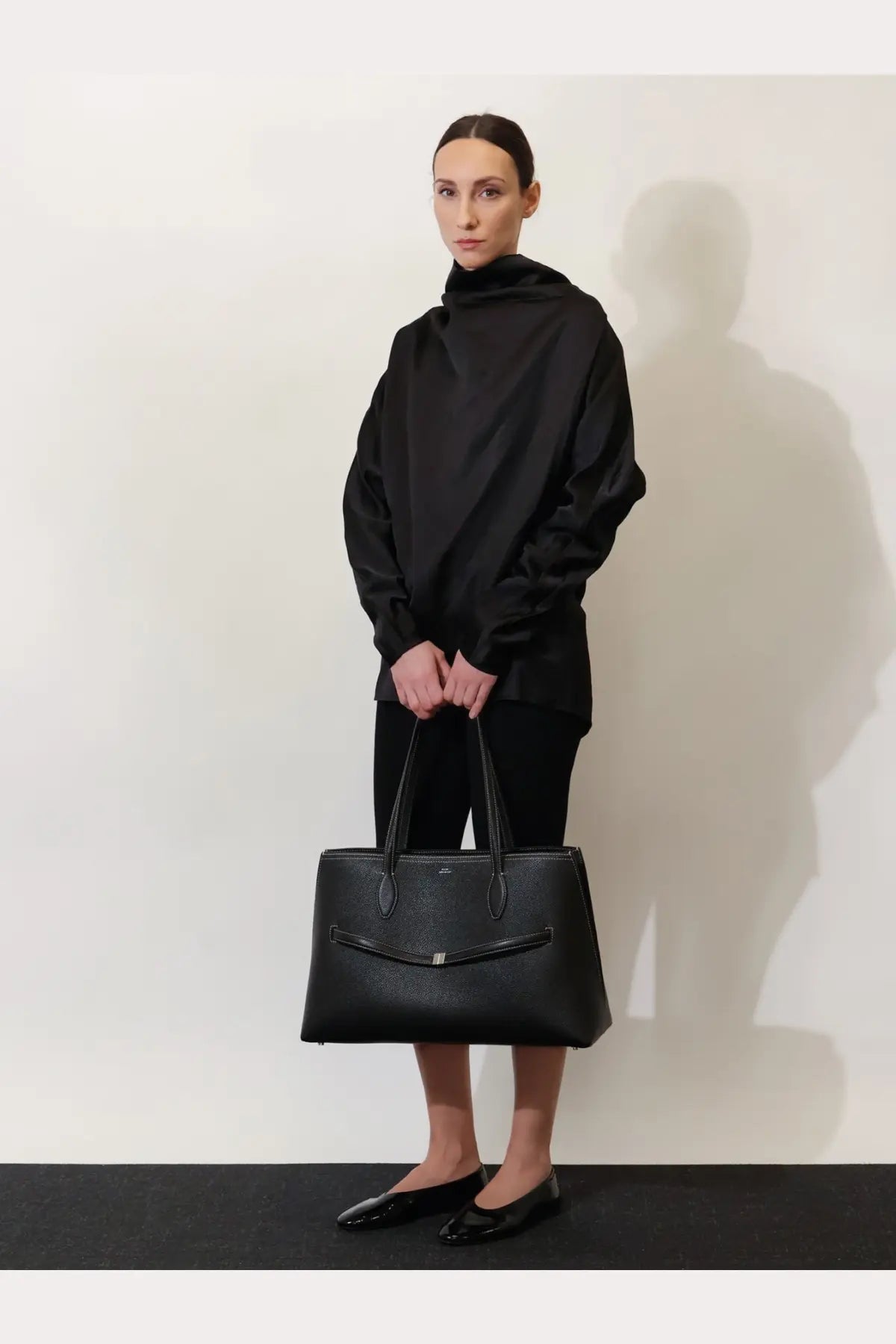 Black leather tote bag with structured design and top handles from Toteme womens shoulder bags collection