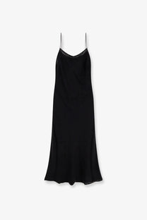 Black satin long slip dress by toteme with delicate spaghetti straps and subtle scalloped hem in silk material