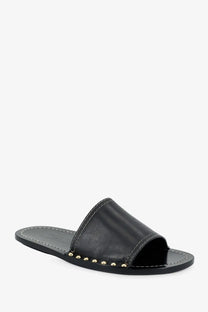 Black leather slide sandal by Toteme with gold-tone studs along the edge in a low heel design
