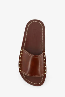 Toteme women’s brown leather slide sandal with gold-tone studs and contrasting white stitching on the strap