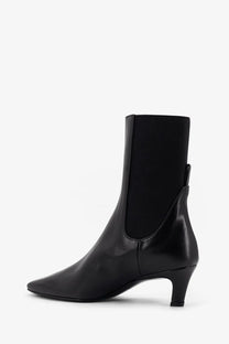 Black leather ankle boot from Toteme with sleek pointed toe and low block heel in black for stylish wear