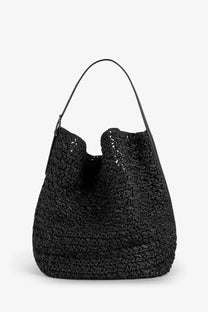 Toteme women’s raffia shoulder bag black featuring a woven straw body with a sleek leather handle