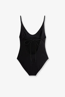 Toteme women’s black nylon one-piece swimsuit with thin straps and tied bow at the back shown from the back side