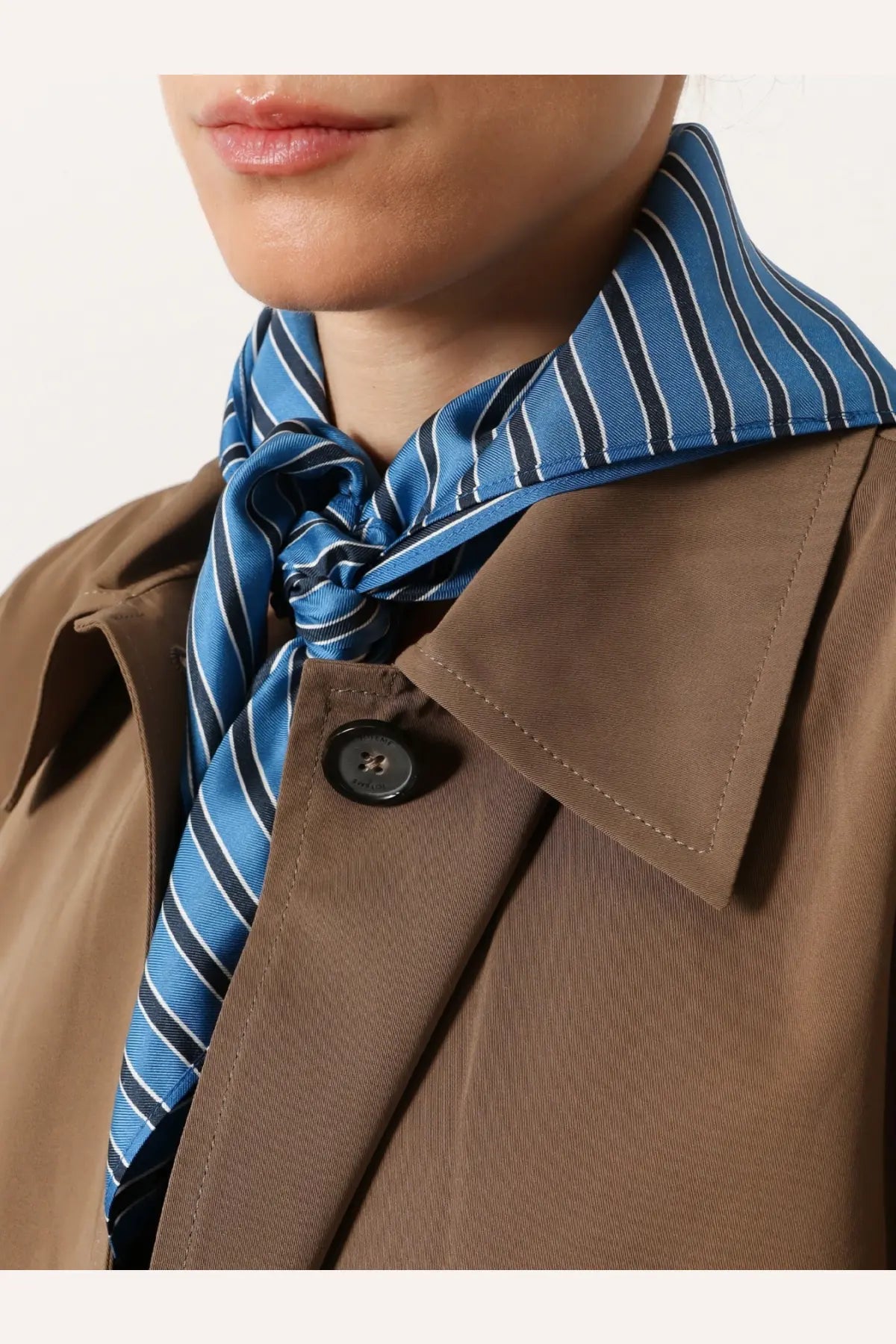 Toteme women’s silk foulard in blue features a blue and black striped silk scarf tied neatly around the neck