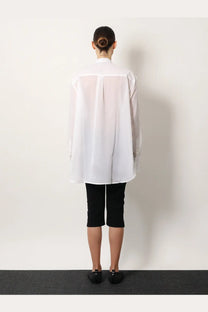 Toteme women’s stand collar organic cotton white shirt translucent with long sleeves worn over black capri pants