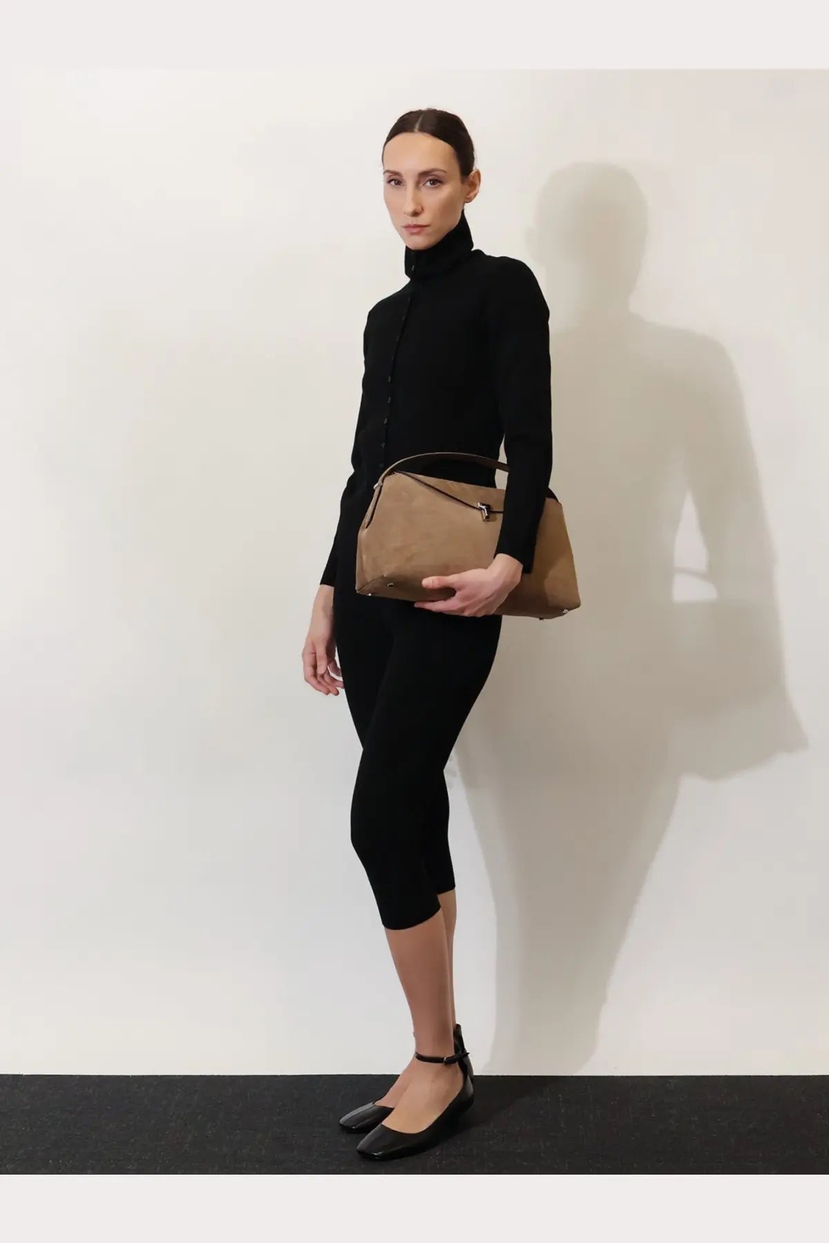 Toteme women’s black viscose blend cardigan paired with a tan leather crossbody bag with minimalist design and gold hardware