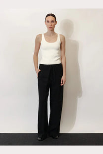 Minimalist black wide-leg pants with drawstring waistband paired with toteme women’s white viscose blend tank top