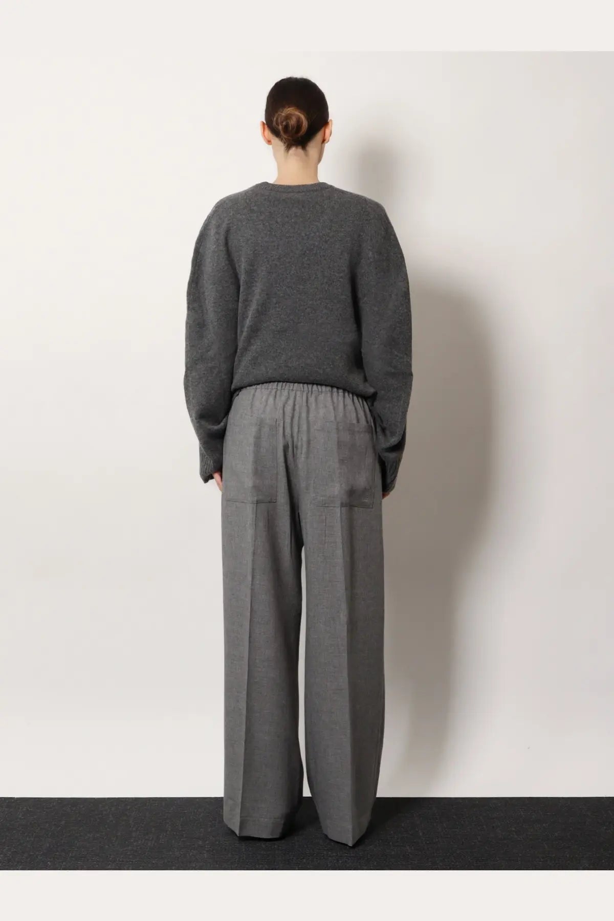 Gray textured knit sweater with relaxed fit and long sleeves paired with toteme women’s viscose grey trousers
