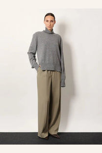 A soft heather gray turtleneck sweater with a relaxed fit and subtle texture paired with toteme beige viscose and wool trousers