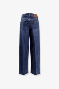 Dark blue wide-leg organic cotton jeans for women by Toteme with a brown leather brand patch at the waistband back view
