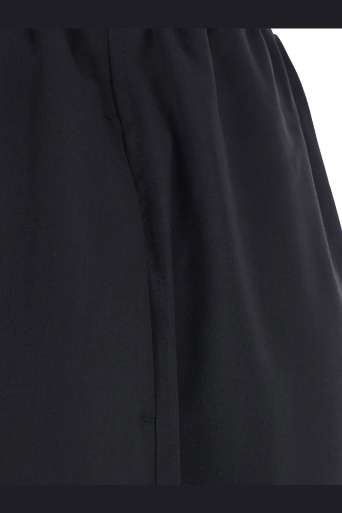 Toteme women’s black wool trouser with smooth slightly wrinkled texture and subtle vertical seam detail