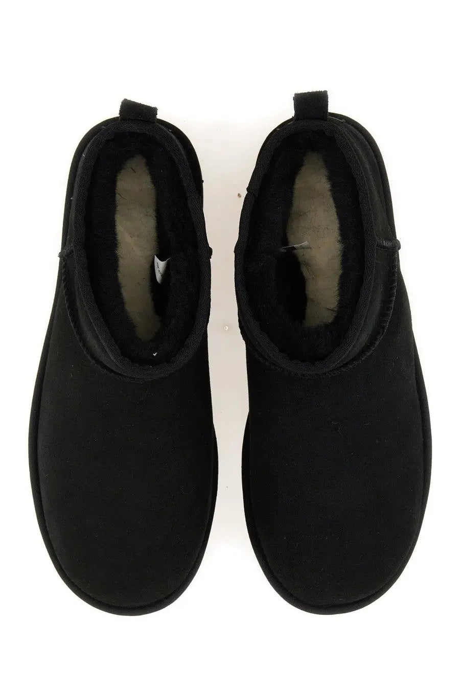 Ugg men’s boot classic ultra mini black showing plush shearling lining in black leather booties