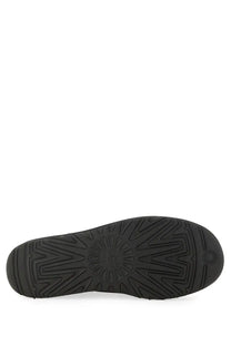 Black rubber sole of ugg men’s boot classic ultra mini black with distinctive starburst tread pattern and embossed logo