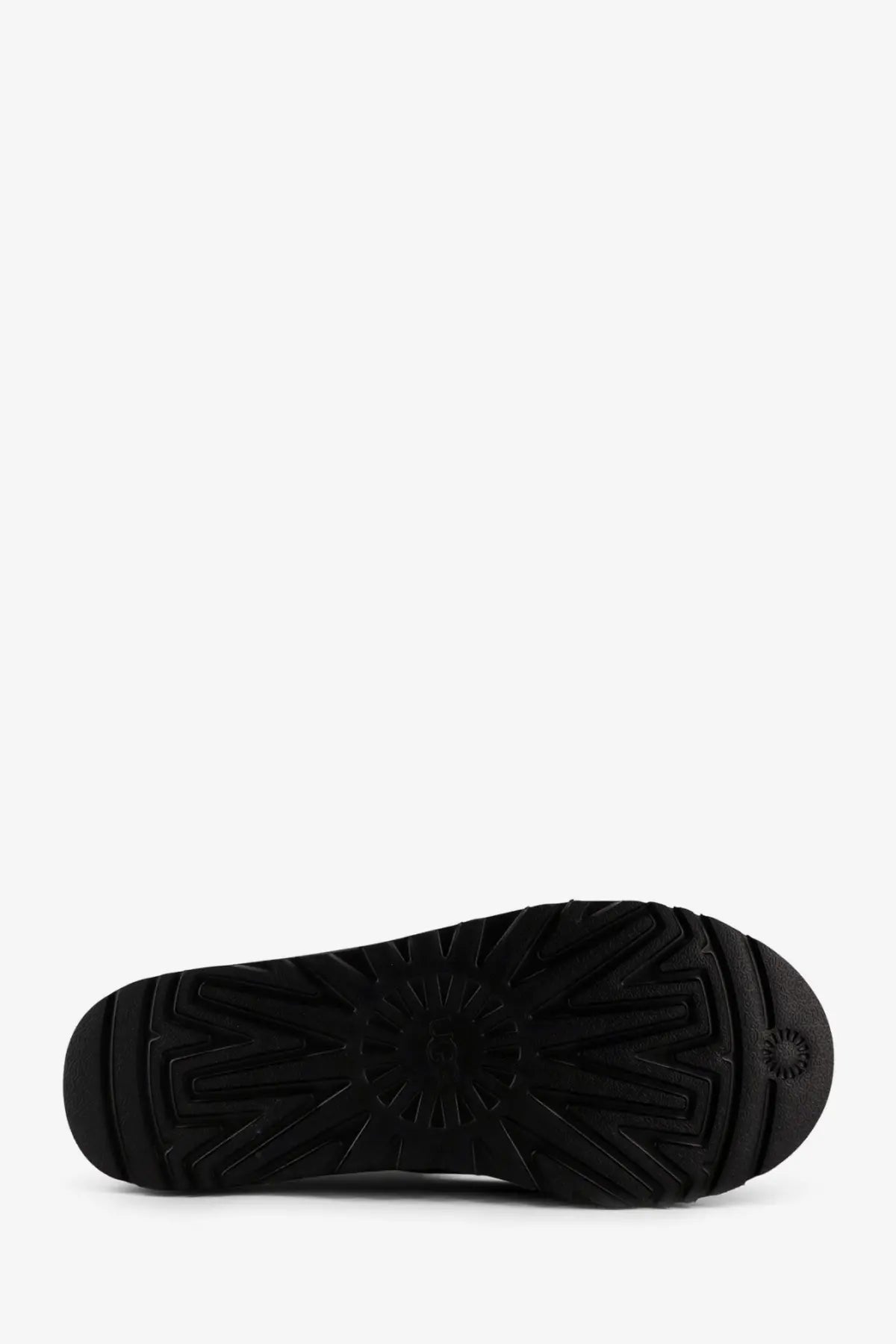 Black rubber sole of ugg men’s tasman noir leather slip with starburst tread pattern and ugg logo near the heel