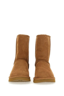 Ugg women’s classic short brown tan suede booties with plush interior and rubber soles for casual wear