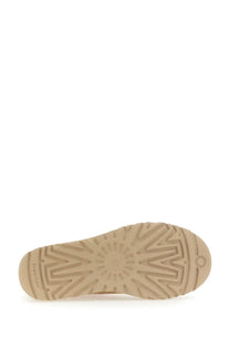 Beige rubber sole with sunburst tread pattern and ugg logo embossed on the heel of ugg womens boot classic ultra mini back side