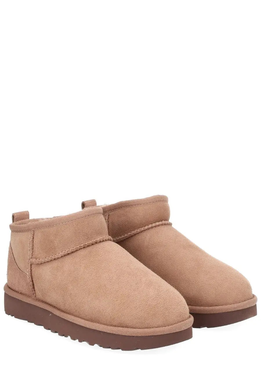 Ugg women’s classic ultra mini beige tan suede ankle boots with brown rubber sole and stitched detailing