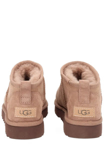 Ugg women’s classic ultra mini beige boot in tan suede with plush shearling lining and brown rubber sole back view