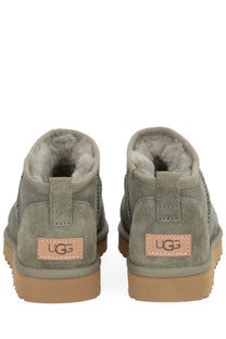 Ugg women’s boot classic ultra mini green olive green suede with tan rubber soles and plush gray lining front view
