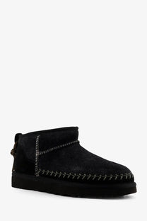 Ugg women’s classic ultra mini biarritz black suede ankle boot with dark stitching and thick rubber sole front view