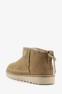 Ugg women’s classic ultra mini biarritz yellow suede ankle boots with tan suede, plush interior, and contrasting stitching