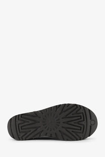 Back view of ugg women’s classic ultra mini grey suede ankle boots with black rubber sole and starburst tread pattern