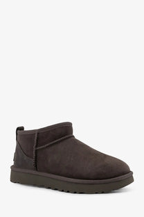 Ugg women’s classic ultra mini dark brown suede ankle boot with chunky rubber sole in grey shown from the back