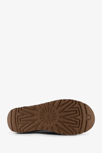 Brown rubber sole with starburst tread pattern and embossed ugg logo on the back of ugg womens classic ultra mini suede boots blue