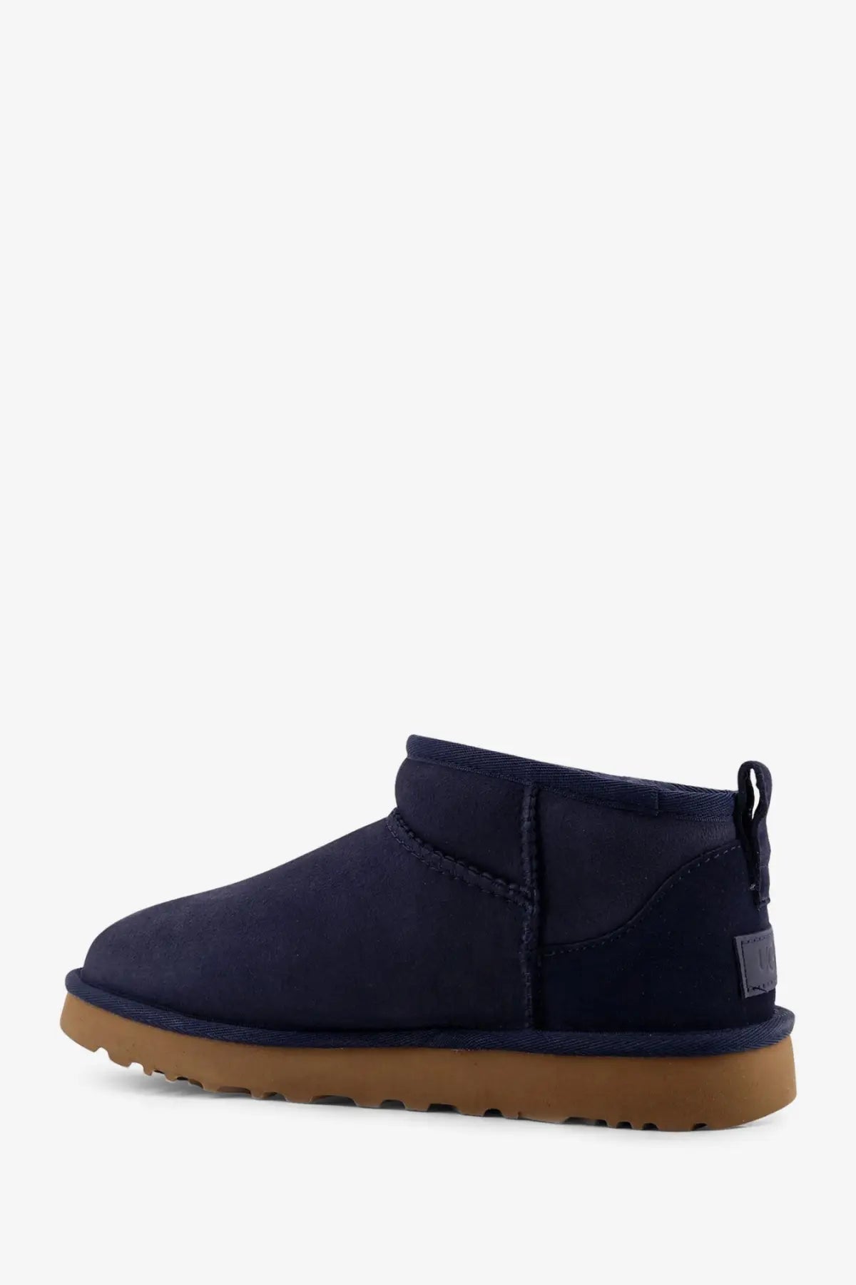 Navy blue suede ugg women’s classic ultra mini boots with tan rubber sole and back pull tab shown from behind