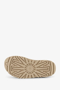 Beige rubber sole with geometric tread pattern and ugg logo on ugg women’s goldenglow leather sandals