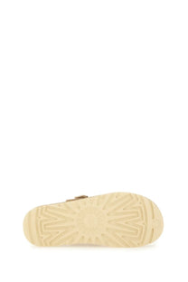 Ugg women’s goldenstar sabot beige with a beige rubber sole featuring a sunburst tread pattern and metallic buckle detail
